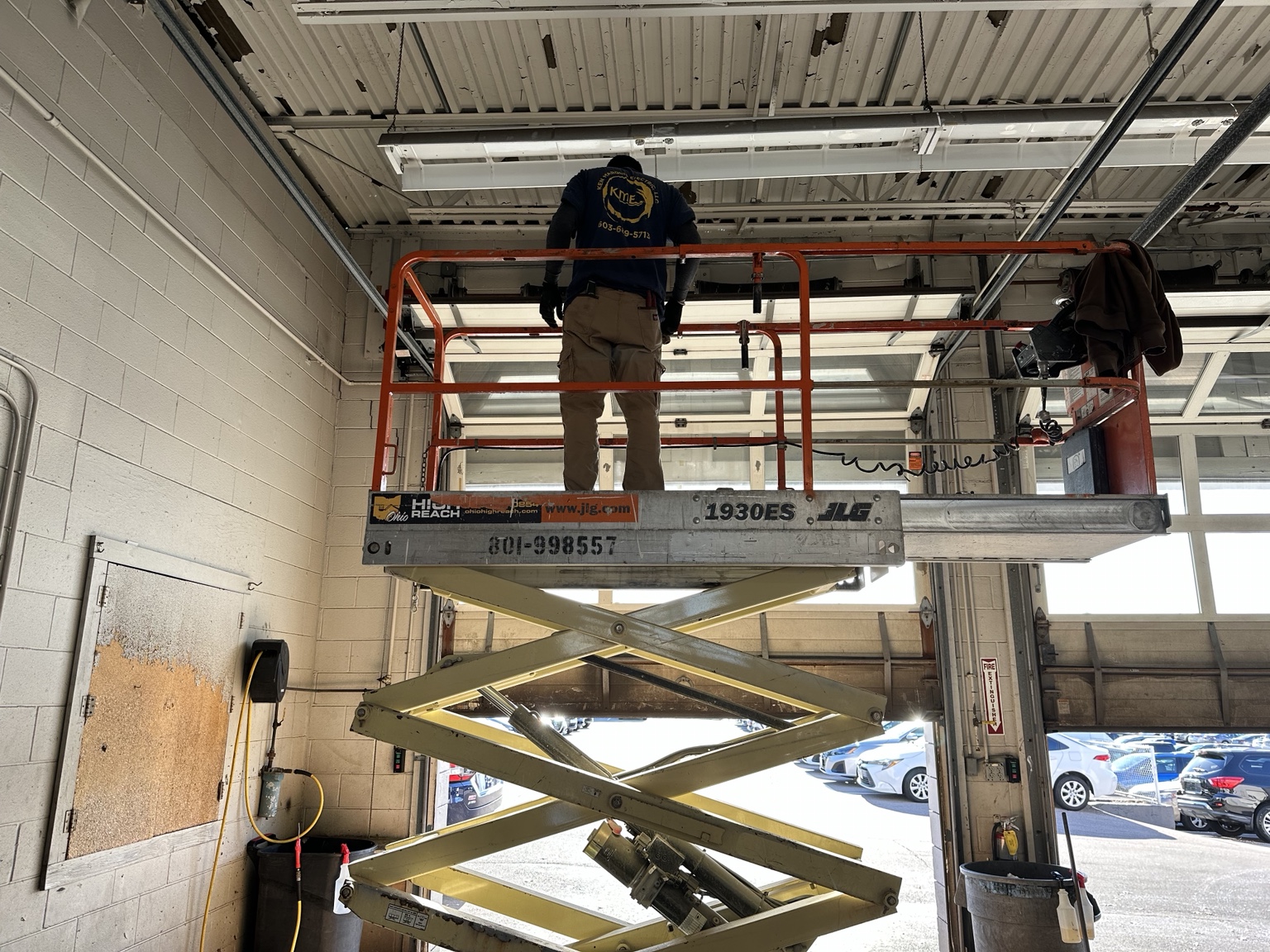 Commercial dealership lighting work from a scissor lift