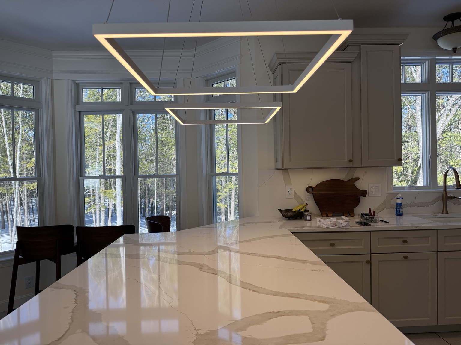 Finished modern LED pendant lighting over kitchen island
